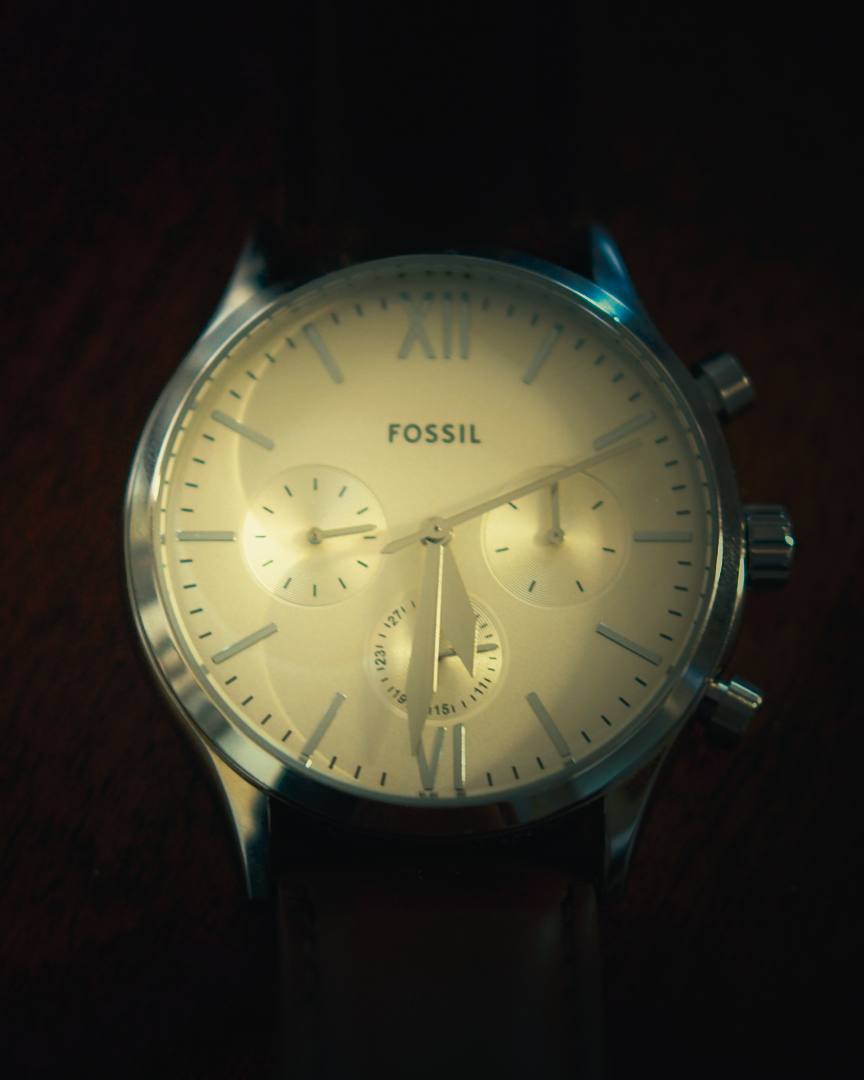 Close-up of a Fossil chronograph watch with cream dial in moody light