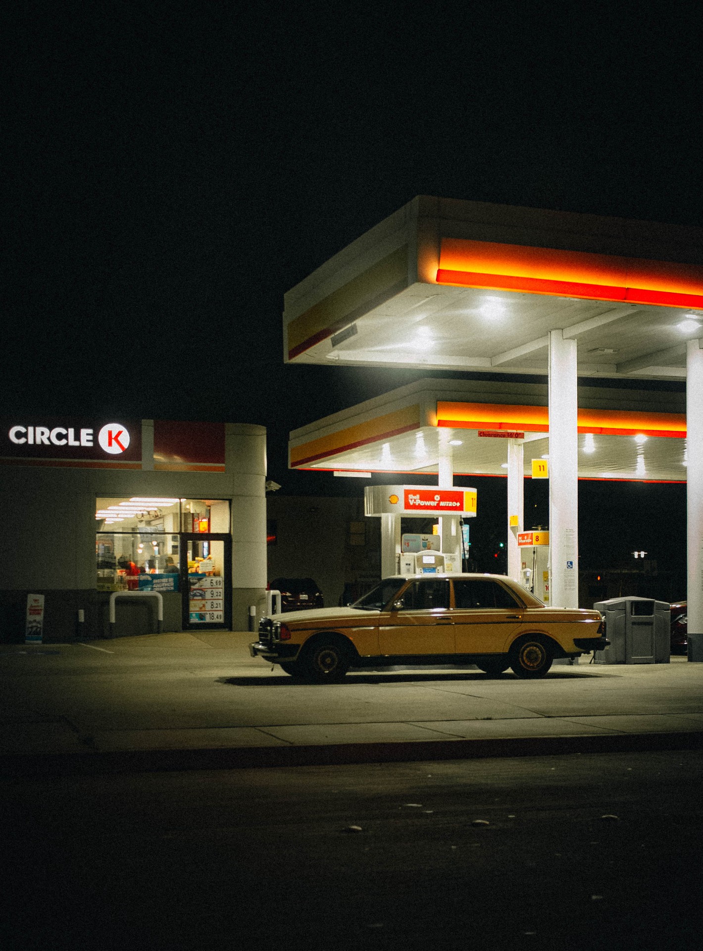 Vintage Mercedes sedan parked at a Circle K Shell gas station at night